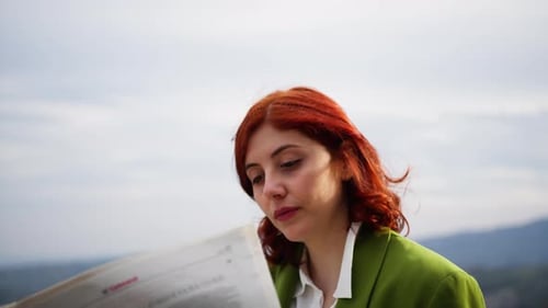 Frau liest Zeitung im Freien im Sonnenlicht