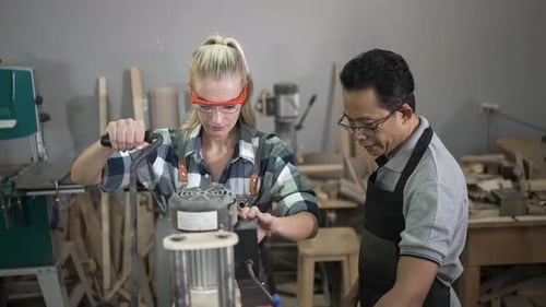 Carpenters are working together at workshop.