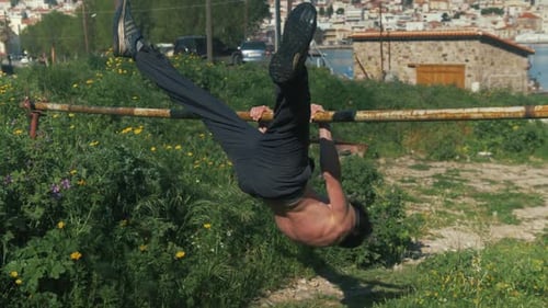 Athletic Young Adult Exercising on Bar in City