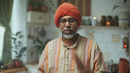 Man Wearing Head Wrap Talking in Kitchen
