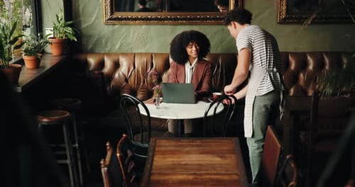 Cafe, waiter and serving with customer on laptop for order, beverage or purchase in restaurant