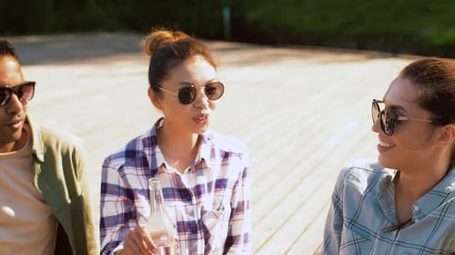 Friends Cheering with Drinks Outside on Sunny Day