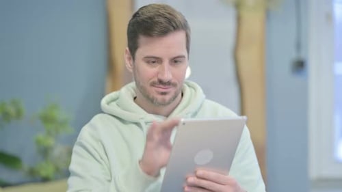 Jeune homme naviguant sur Internet sur tablette numérique