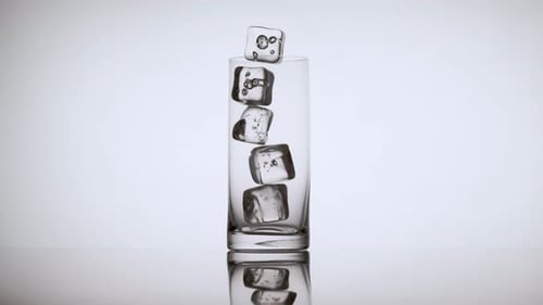 Multiple Ice Cubes Falling into an Empty Glass