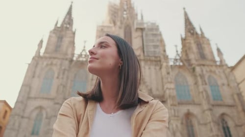 Close-up of young woman traveler sitting on the square of the old city, view from below