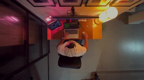 Top View Zoom Out Shot: In the Office Businessman home office Sitting at the Wooden Desk Opens Lapto