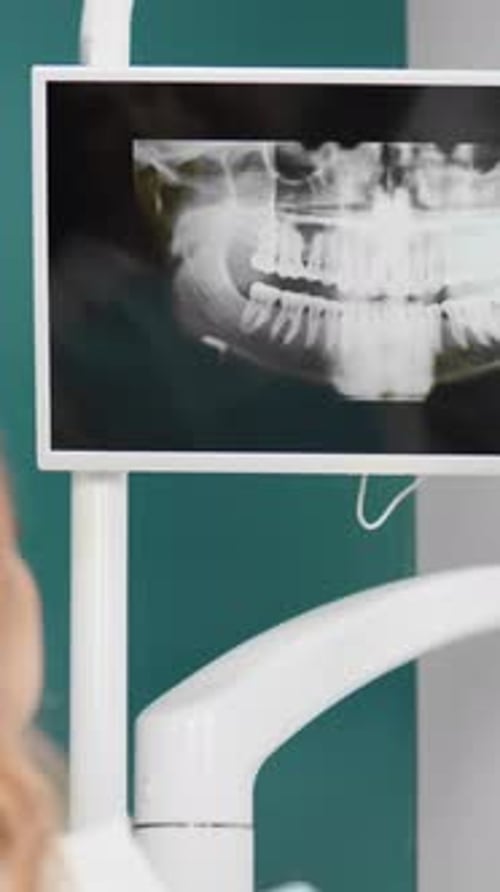 Dentist Examining X-Ray on Monitor in Dental Clinic