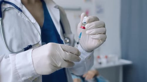 Medical Professional Drawing Vaccine into Syringe