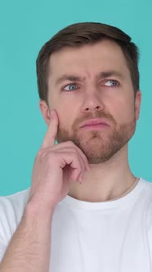Young Adult Man Thinking Hard on Turquoise Background