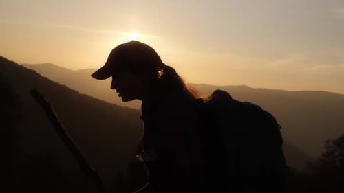Silhouette Hiker with Walking Stick During Mountain Sunrise