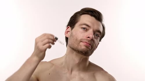 Man Applies Skincare Serum to Face