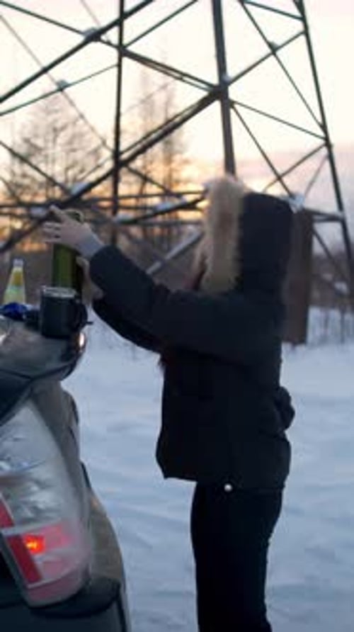 Woman Prepares Beverages in Snowy Winter Landscape