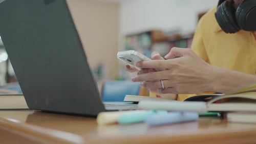 Close up shot of hands typing smartphone for AI assistance analysis data in university library.