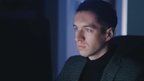 Junger Geschäftsmann arbeitet spät in der Nacht am Laptop