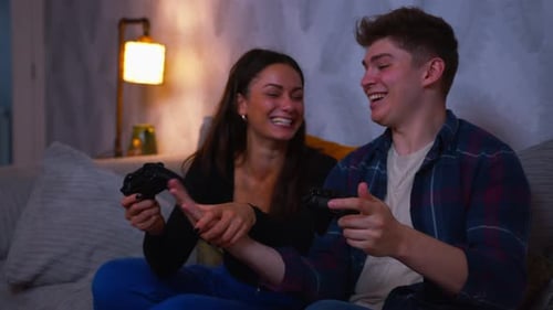 Young Couple Playing Video Games Together on Couch