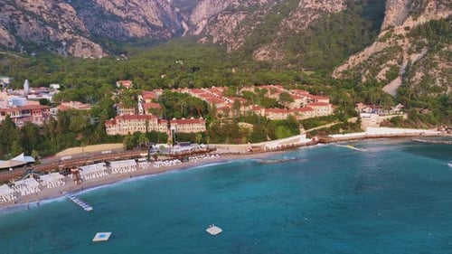 Luxurious Mediterranean Resort Nestled Among Verdant Mountains Featuring Turquoise Waters Gently