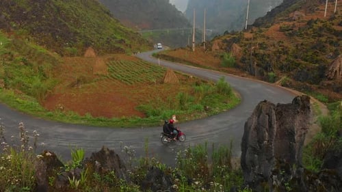 Aerial view of winding road through mountains and fields, Vietnam.