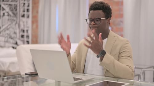 Frustrated Young Man Working at Laptop in Office