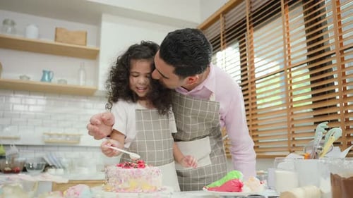 Asian attractive father making cake with daughter in kitchen at house.