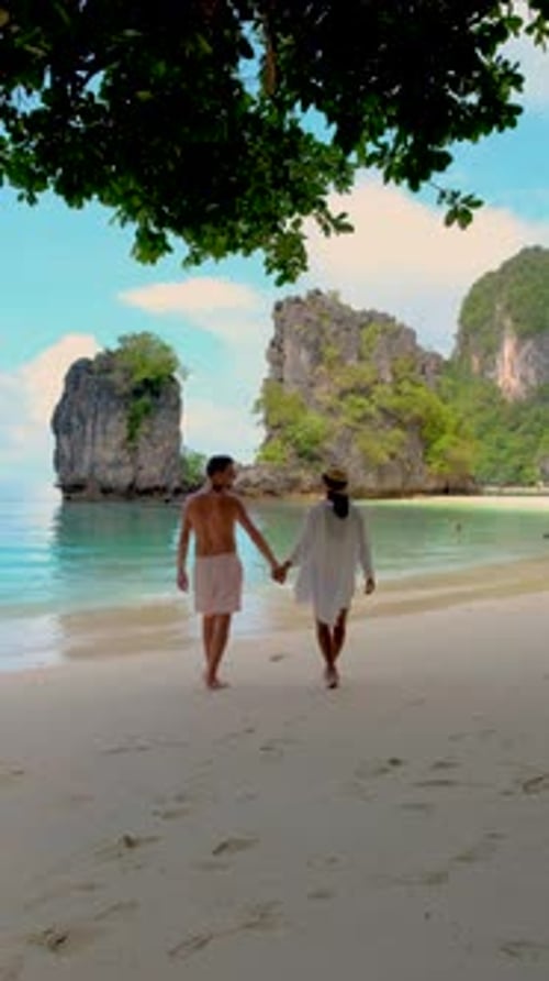Couple Holding Hands Walking on Tropical Beach