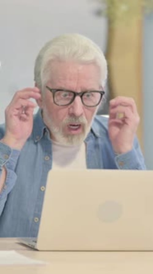 Worried Senior Man Using Laptop at Desk