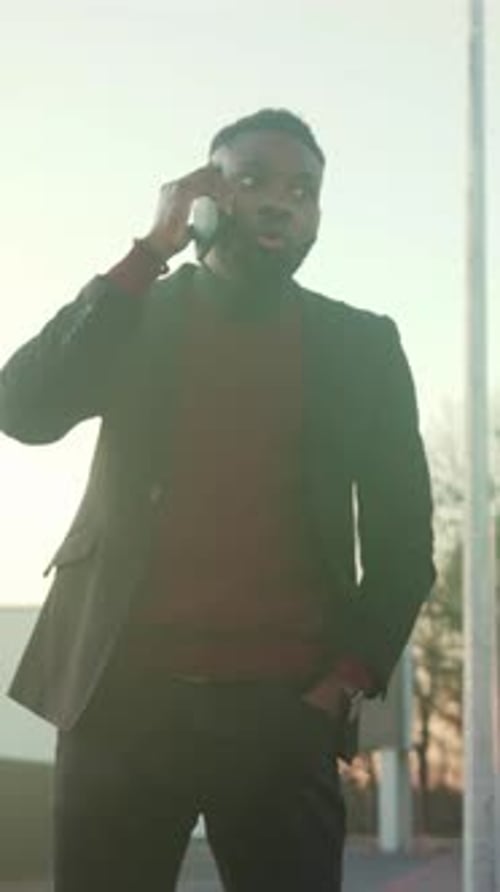 Man in Suit Talks Urgently with Style Professional in Burgundy Sweater Makes Important Business Call