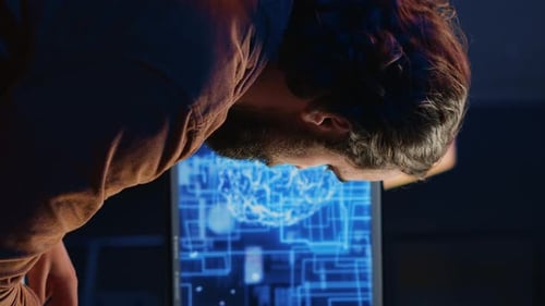 Man Examining Digital Brain on Computer Screen