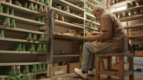 Mature Shoemaker at Work in Cobbler Workshop