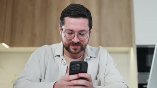 Young Adult Using Smartphone at Home