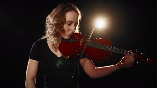Violinist Playing Classical Music in Dark Setting