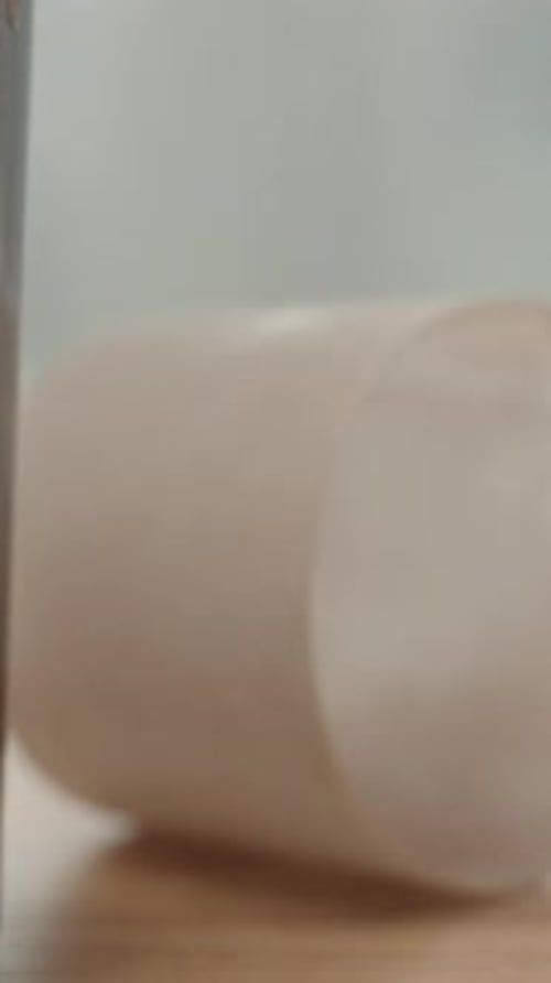 Vertical video. I pour milk into a glass with protein powder for a sports cocktail.