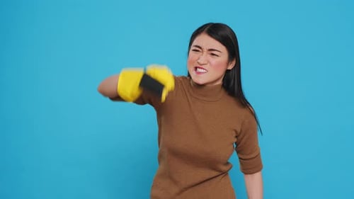 Woman Scrubbing with Glove Against Blue Background