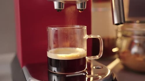 Espresso being Brewed into Glass Mug in Kitchen