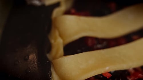 Gloved Hand Places Dough Strips on Pie