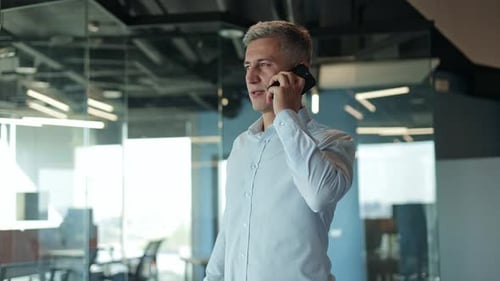 Businessman Having a Cheerful Phone Call in the Office