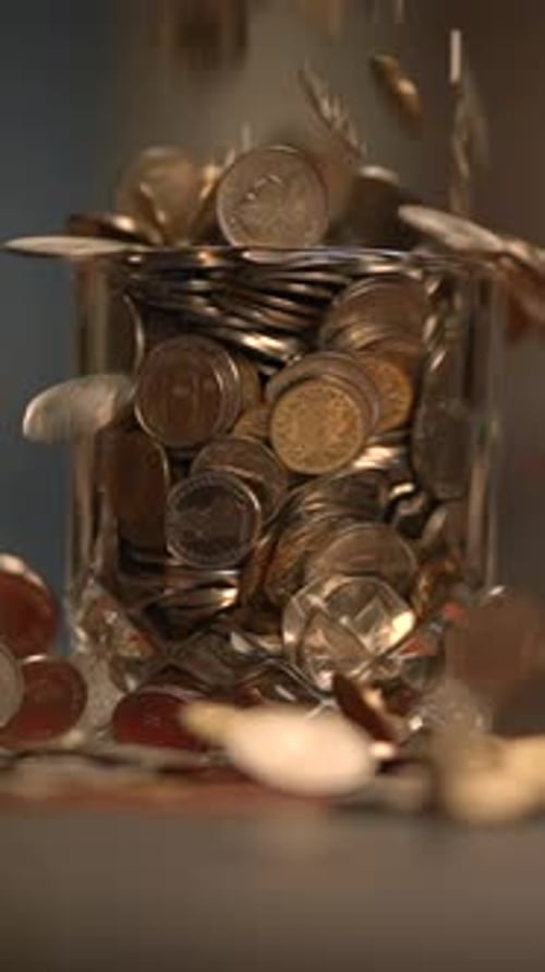 Monedas recogidas en un estético tarro de cristal que exploran los conceptos de moneda y ahorro
