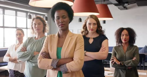 Portrait of confident diverse businesswomen standing in office with arms crossed, in slow motion