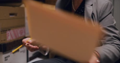 Professional woman focuses on files in dark lawyer office interior