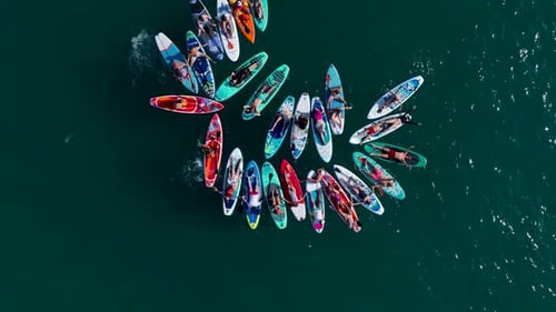 Observe a Group of Friends Having Fun Paddleboarding at a SUP Festival in the Mediterranean Sea