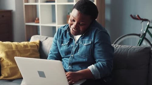Man Talking on Phone While Working on Laptop