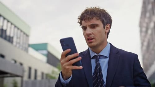 Frustrated Employee Reading Mobile Phone Message on Business Street Closeup