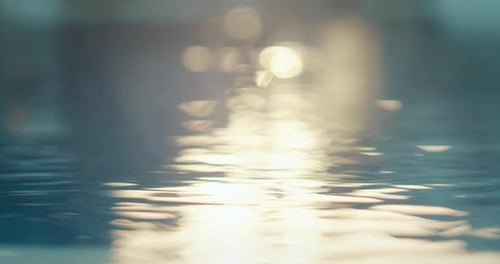 Goldene Reflexionen ziehen sich während des Sonnenuntergangs im Resort über die Wasseroberfläche
