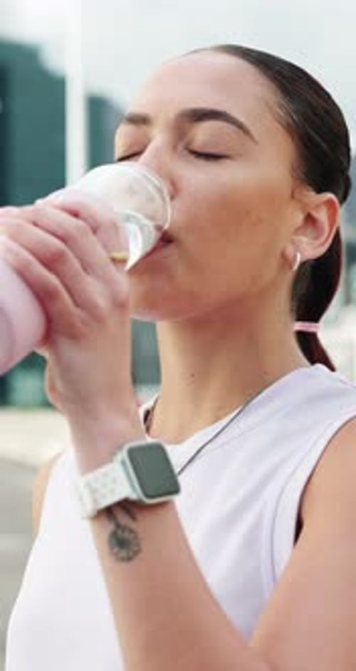Fitness, woman and drinking water in city with bottle for sports hydration