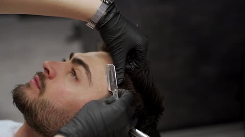 Close Up of Barber Giving Haircut with Razor