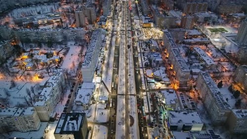 Aerial drone view of Chisinau city covered in snow with moving traffic in the night. Blue hour durin