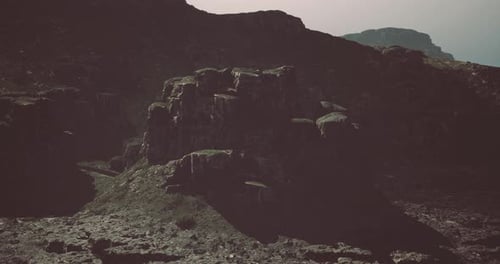 Rocky Landscape with Rugged Cliffs and Mountains During Overcast Weather