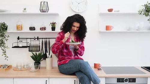 Woman Enjoys Salad in a Bright Kitchen