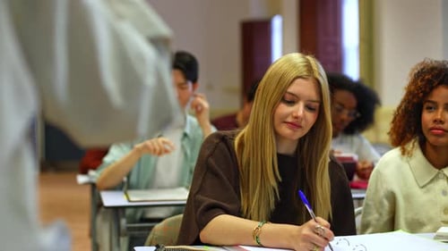 Blonde High School Student Listening to Teacher in Classroom