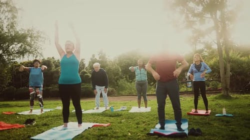Happy senior friends having fun doing workout activity in a public park