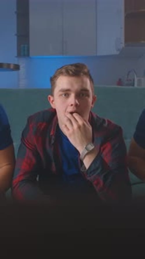 Young Man Sitting on a Sofa in a Modern Apartment Living Room Looking Directly at the Camera and